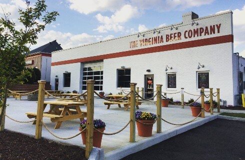 Exterior of a brewing company with an outdoor patio with picnic tables